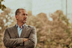 Portrait of modern senior businessman in suit with crossed arms photo