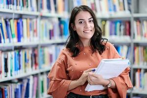 the student uses a notebook and a school library photo