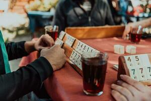 A group of men drink traditional Turkish tea and play a Turkish game called Okey photo