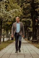 Focused businessman in a suit walking in the park photo