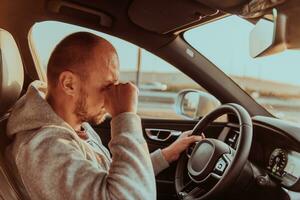 un cansado conductor participación su cabeza. agotado y cansado conductor conducción un coche a puesta de sol foto