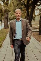 Focused businessman in a suit walking in the park photo