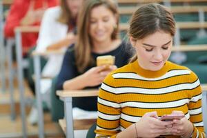 famel students using smartphone in classroom photo