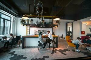 Group of casual multiethnic business people taking break from the work doing different things while enjoying free time in relaxation area at modern open plan startup office photo