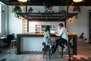 Group of casual multiethnic business people taking break from the work doing different things while enjoying free time in relaxation area at modern open plan startup office photo