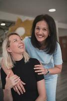 Portrait of two hugging female teachers in a preschool institution, in the background of the classrooms photo