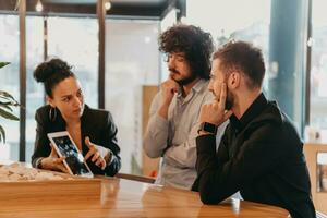 A group of friends hanging out in a cafe, and among them is a tablet. photo