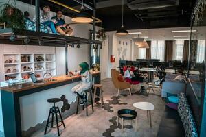 Group of casual multiethnic business people taking break from the work doing different things while enjoying free time in relaxation area at modern open plan startup office photo