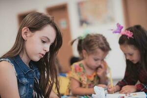 creativo niños sentado en un preescolar institución, dibujar y tener divertido mientras ellos obtener un educación foto