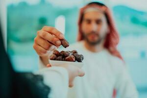 Modern multiethnic muslim family sharing a bowl of dates while enjoying iftar dinner together during a ramadan feast at home photo