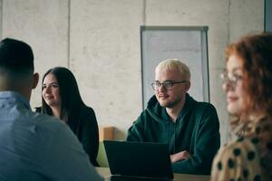 A diverse group of business professionals gathered at a modern office for a productive and inclusive meeting photo