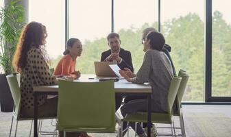 A diverse group of business professionals gathered at a modern office for a productive and inclusive meeting photo