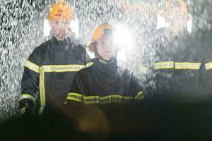 Portrait of a group of firefighters standing and walking brave and optimistic with a female as team leader. photo