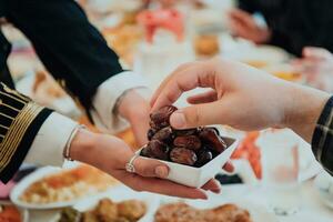 Modern multiethnic muslim family sharing a bowl of dates while enjoying iftar dinner together during a ramadan feast at home photo