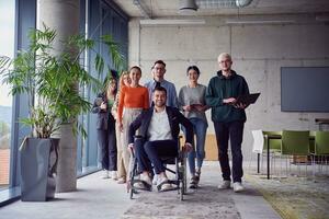 A diverse group of businessmen, including a businessman in wheelchair, confidently stride together through a modern, spacious office, epitomizing collaboration, inclusivity, and strength in unity photo