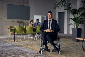 Businessman in a wheelchair commands attention, symbolizing resilience and success amidst a dynamic modern office environment. photo