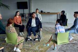 A businessman in a wheelchair in the center of the circle, passionately sharing his business ideas with his colleagues, fostering an atmosphere of collaboration and innovation in a dynamic and engaging workplace. photo