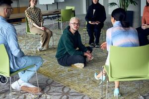 A man sitting at the center of a circle, passionately sharing his business ideas with his colleagues, fostering an atmosphere of collaboration and innovation in a dynamic and engaging workplace. photo