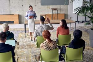 A group of young business professionals in a modern office attentively listens to colleague presentation, showcasing a dynamic and collaborative atmosphere as they exchange ideas and strive for success. photo