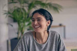 en un moderno oficina, un joven sonrisa mujer de negocios con lentes con confianza explica y regalos varios negocio ideas a su colegas, exhibiendo su profesionalismo y pericia. foto