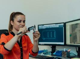 Within the heavy industry, a factory industrial engineer measures with a caliper and on a personal computer Designs a 3D model photo