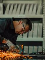 Heavy Industry Engineering Factory Interior with Industrial Worker Using Angle Grinder and Cutting a Metal Tube. Contractor in Safety Uniform and Hard Hat Manufacturing Metal Structures. photo