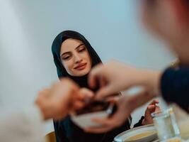 Modern multiethnic muslim family sharing a bowl of dates while enjoying iftar dinner together during a ramadan feast at home photo