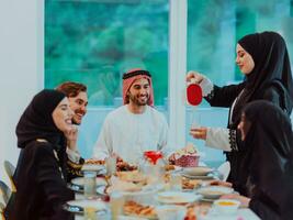 eid Mubarak musulmán familia teniendo iftar cena Bebiendo agua a descanso banquete. comiendo tradicional comida durante Ramadán banquete mes a hogar. el islámico halal comiendo y Bebiendo foto