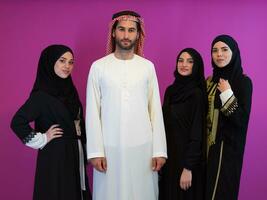 grupo retrato de joven musulmán personas árabe hombre con Tres musulmán mujer en de moda vestir con hijab aislado en rosado antecedentes representando moderno islam Moda y Ramadán kareem concepto foto