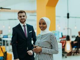 Portrait of a formal businessman and young African American businesswoman posing with their team in a modern startup office. Marketing concept. Multi-ethnic society. photo