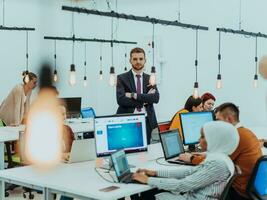 Group of multi-ethnic colleagues working on desktop computers, laptop and sharing their ideas in a modern office space.Young influencers work on online marketing projects. photo