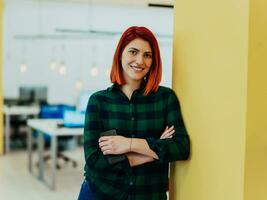 Headshot portrait of a modern woman with crossed arms in the office at night by the window photo