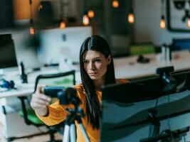 A young woman using a camera to present her business with online clients photo