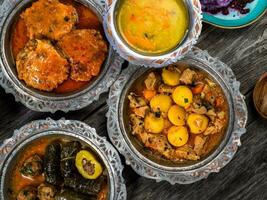 eid Mubarak tradicional Ramadán iftar cena. clasificado sabroso comida en auténtico rústico platos en de madera azul antecedentes. turco bosnio comida carne brocheta, Agave, sarma, klepe, sogan dolma. foto