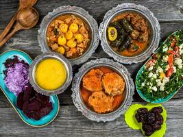 Eid Mubarak Traditional Ramadan Iftar dinner. Assorted tasty food in authentic rustic dishes on wooden blue background. Turkish Bosnian food meat kebab, pita, Sarma, klepe, sogan dolma. photo