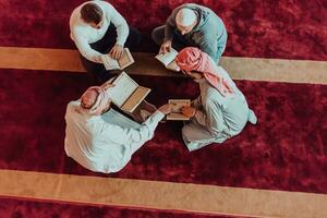 A group of Muslims reading the holy book of the Quran in a modern mosque during the Muslim holiday of Ramadan photo