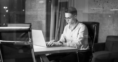 hombre trabajando en una laptop en una oficina oscura foto