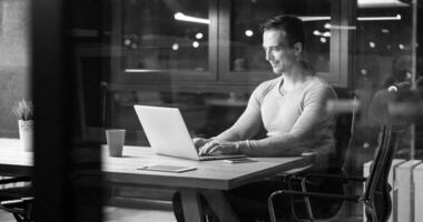 hombre trabajando en una laptop en una oficina oscura foto