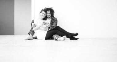 Young Couple using digital tablet on the floor photo