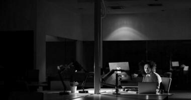 hombre trabajando en una computadora en una oficina oscura foto