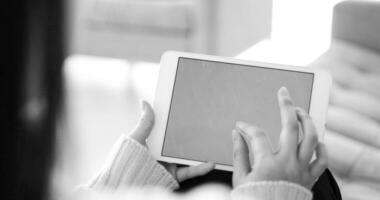 woman on sofa using tablet computer photo