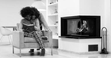 multiethnic couple hugging in front of fireplace photo