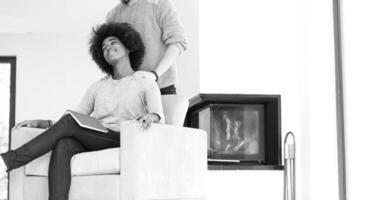 multiethnic couple hugging in front of fireplace photo