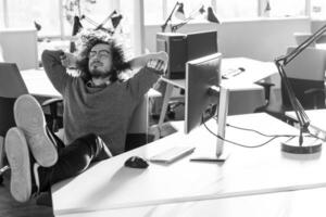 businessman sitting with legs on desk photo