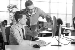 dos personas de negocios que trabajan con una computadora en la oficina foto