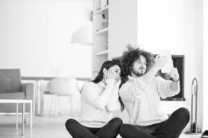 multiethnic couple using tablet computer in front of fireplace photo