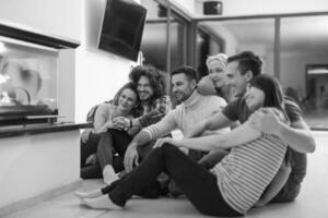 multiethnic couples sitting in front of fireplace photo