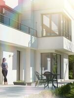 women using tablet computer in front of luxury home villa photo