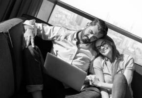 couple relaxing at  home using laptop computers photo