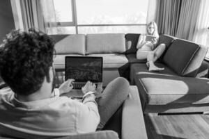 couple relaxing at  home using tablet and laptop computers photo